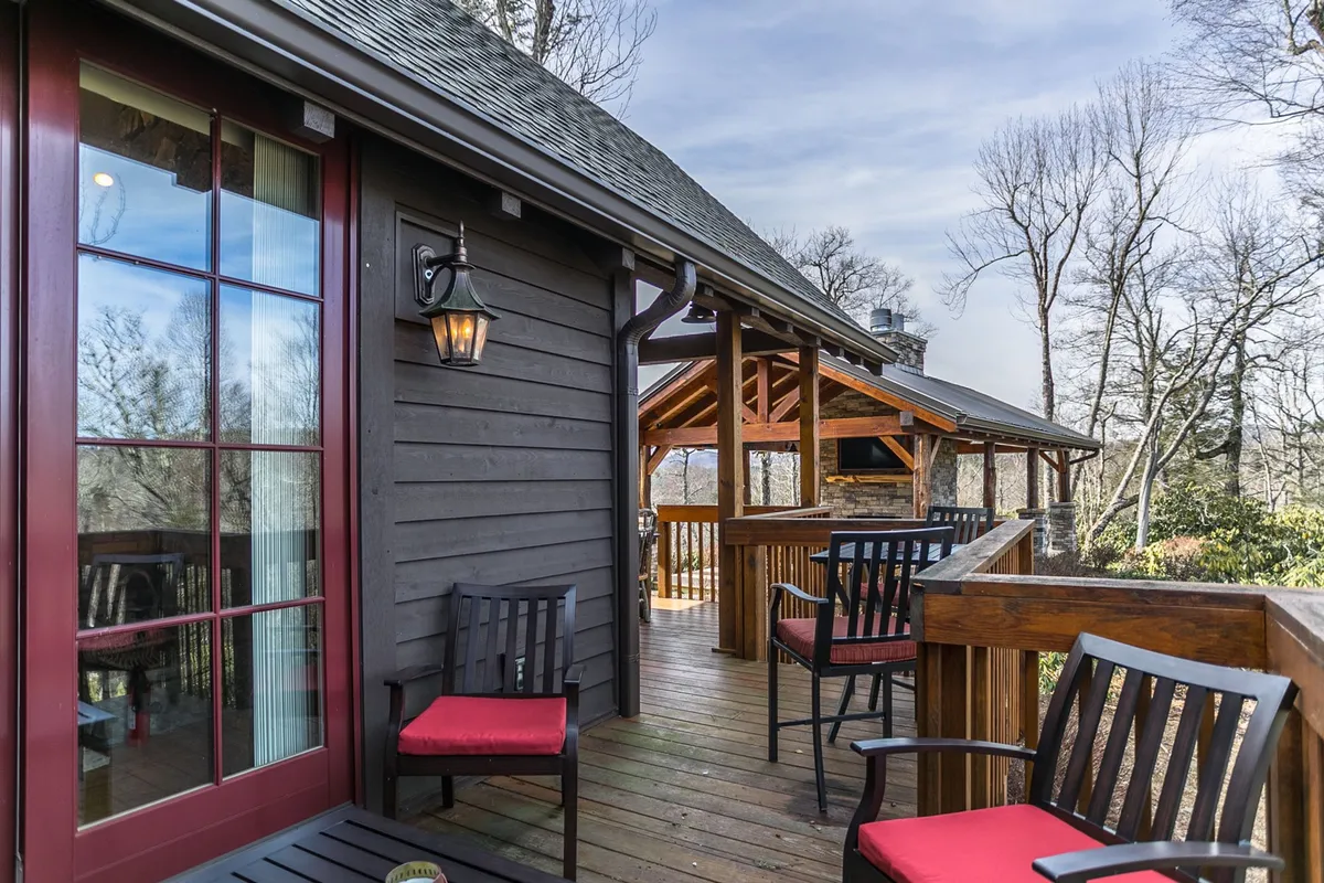 A peaceful wooden deck with comfortable seating and a clear view of the mountains, decorated with a lantern. The setting is tranquil and inviting, ideal for relaxing, socializing, and soaking up the scenic vistas.